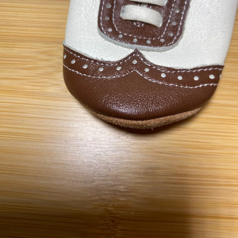 White and brown wingtip baby shoes